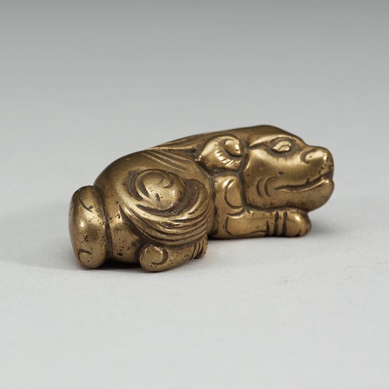 A bronze paper-weight modeled as a reclining lion, Qing dynasty, presumably 18th Century.