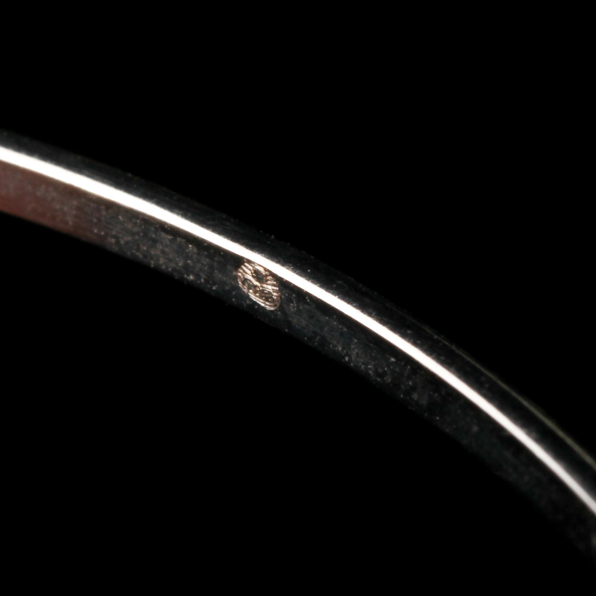 ARMRING, 18k vitguld med 2 åttkantslipade diamanter, 0.03 ct samt 2 fasettslipaded blå safirer. Vikt 6 g.