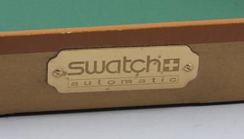 OLIKA KONSTNÄRER, objekt innehållande 5 signerade serigrafier samt Swatch Automativ Gran Via armbandsur.