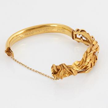 An 18K gold bangle set with an old-cut diamond.