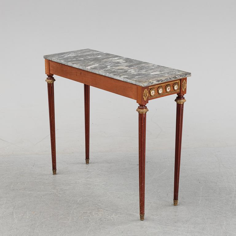 A Louis XVI style console table with a marble top.