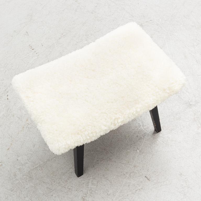 A mid 20th Century stool with sheepskin upholstery.