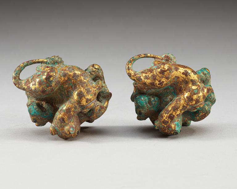 A pair of gilt bronze archaistic weights.