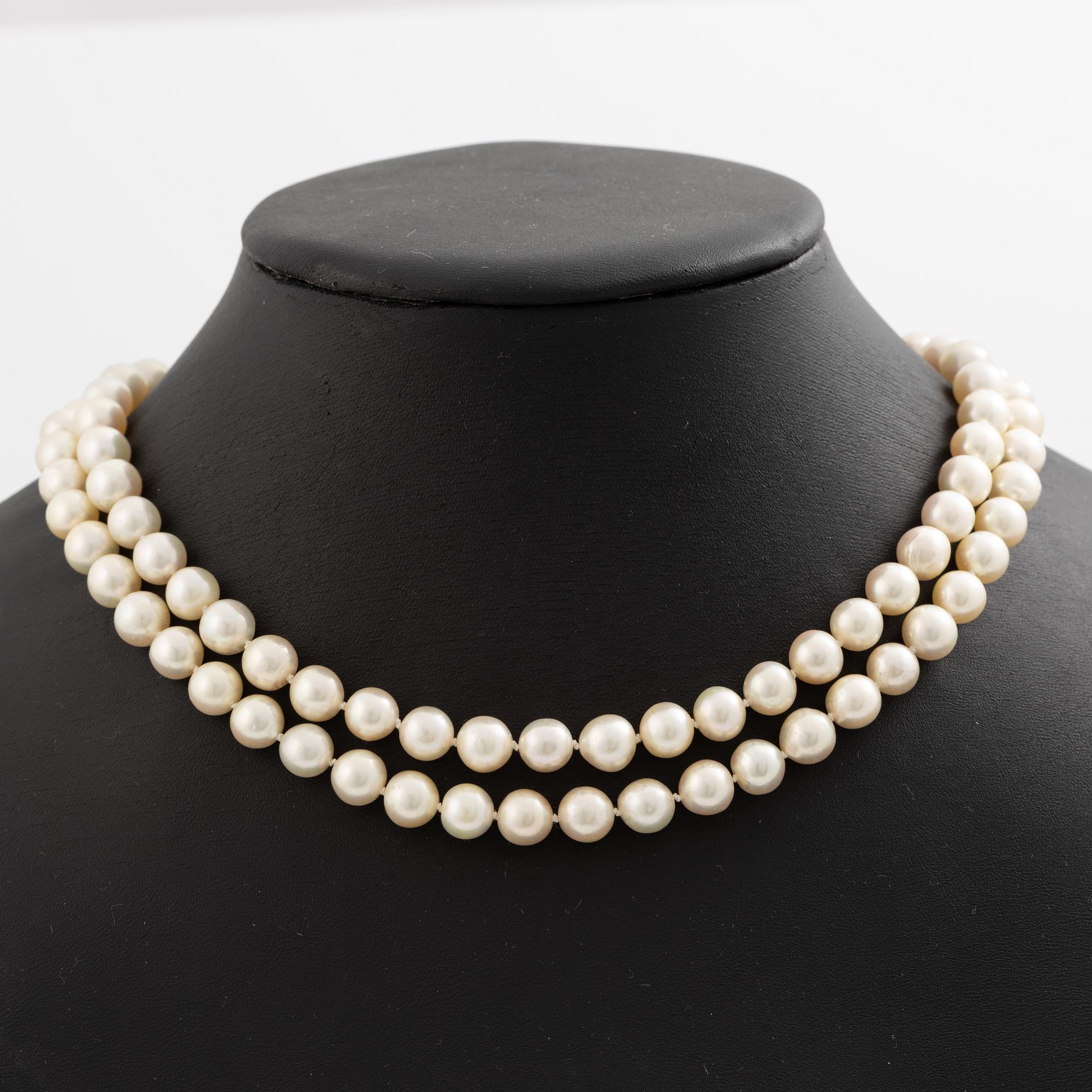 Pearl necklace, two-stranded, with a clasp by Seblings in 18K gold set with emeralds, rubies, and brilliant-cut diamonds.