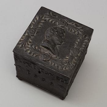 An empire cast iron tobacco box, dated 1838.