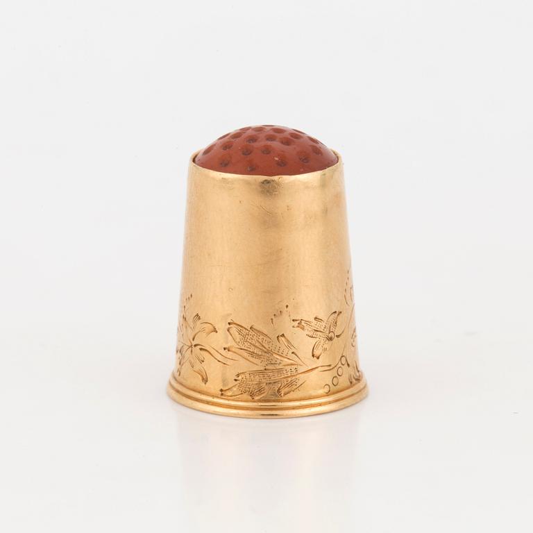 A thimble set with carnelian.