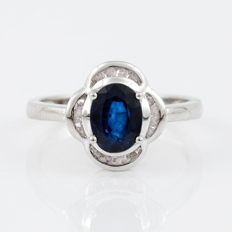 RING, 14K vitguld med ovalslipad safir tot ca 1,24 cts omgivs av 16 åttkantslipade diamanter. Vikt 3,47 g.