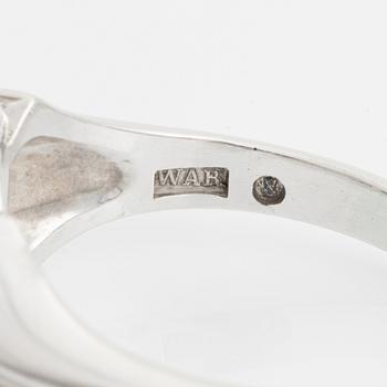 An 18K white gold ring set with a cabochon-cut emerald and eight-cut diamonds.