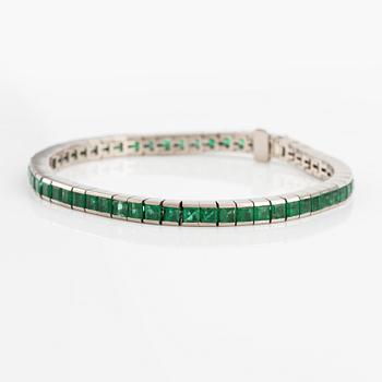 An 18K white gold bracelet with step-cut emeralds.