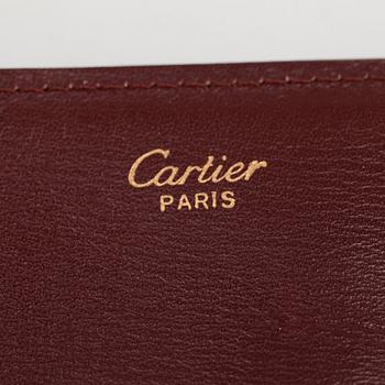 CARTIER, a red leather clutch or travel wallet.