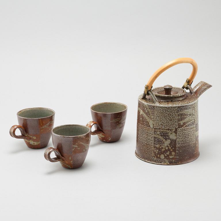 A tea pot and three tea cups in saltglazed stoneware by Christer Sjöblom, signed tea pot.