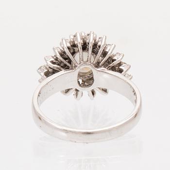 An 8K white gold ring set with a gray cabochon cut star sapphire and single cut diamonds.