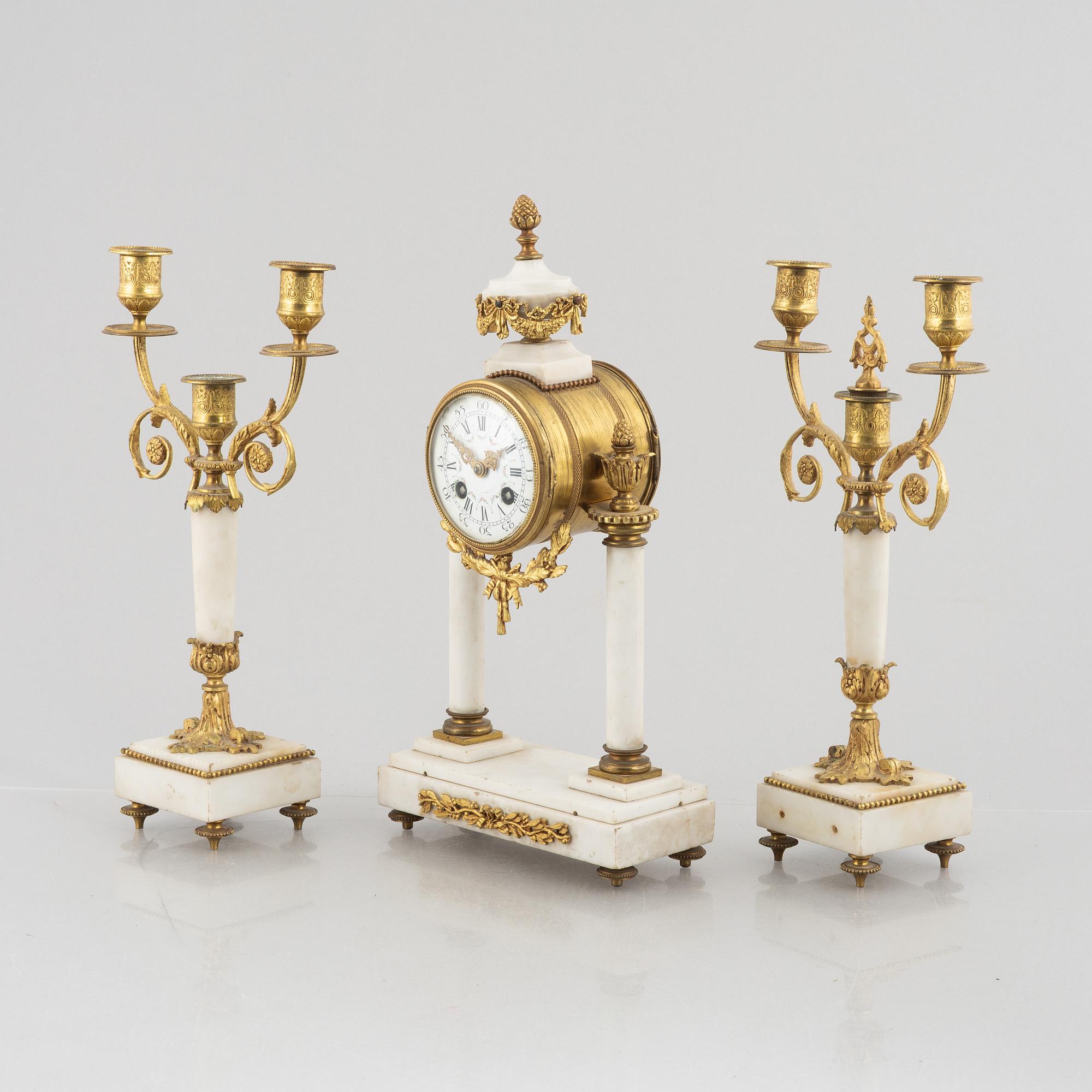 A Louis XVI-style mantel clock Paris, France and a pair of candelabras, late 19th century.