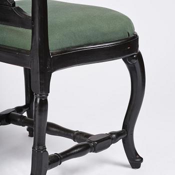 A set of eight black Swedish rococo chairs.