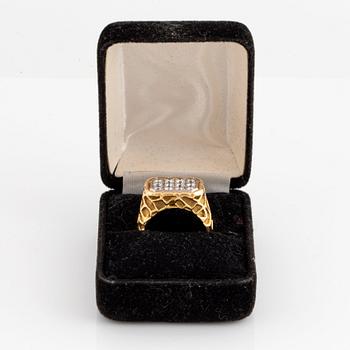 An 18K gold ring set with round brilliant-cut diamonds.