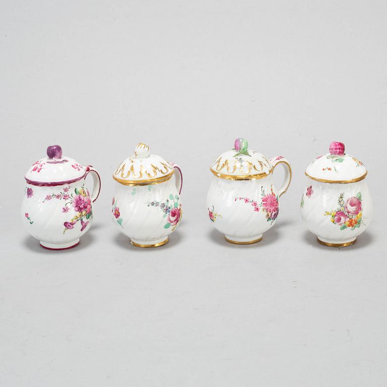 A set of four odd soft paste custard cups with covers, 18th Century.