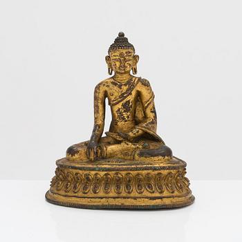A gilt copper alloy figure of Buddha, Tibet/Nepal 15th Century.