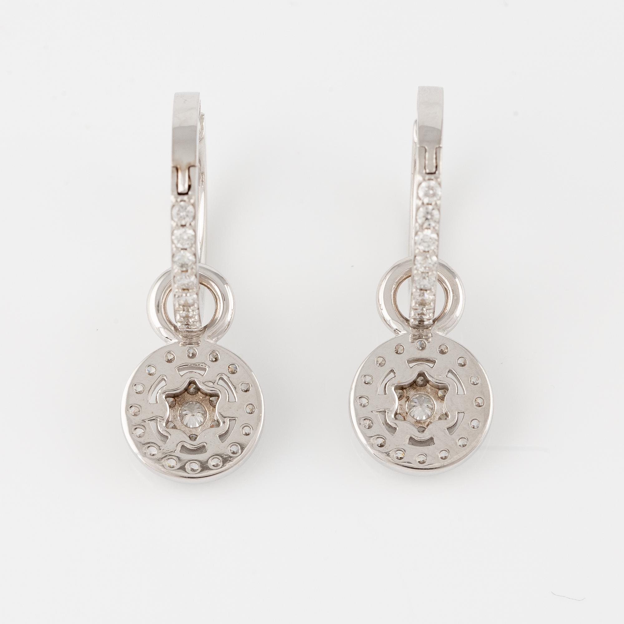 A pair of 18K gold earrings with round brilliant-cut diamonds.