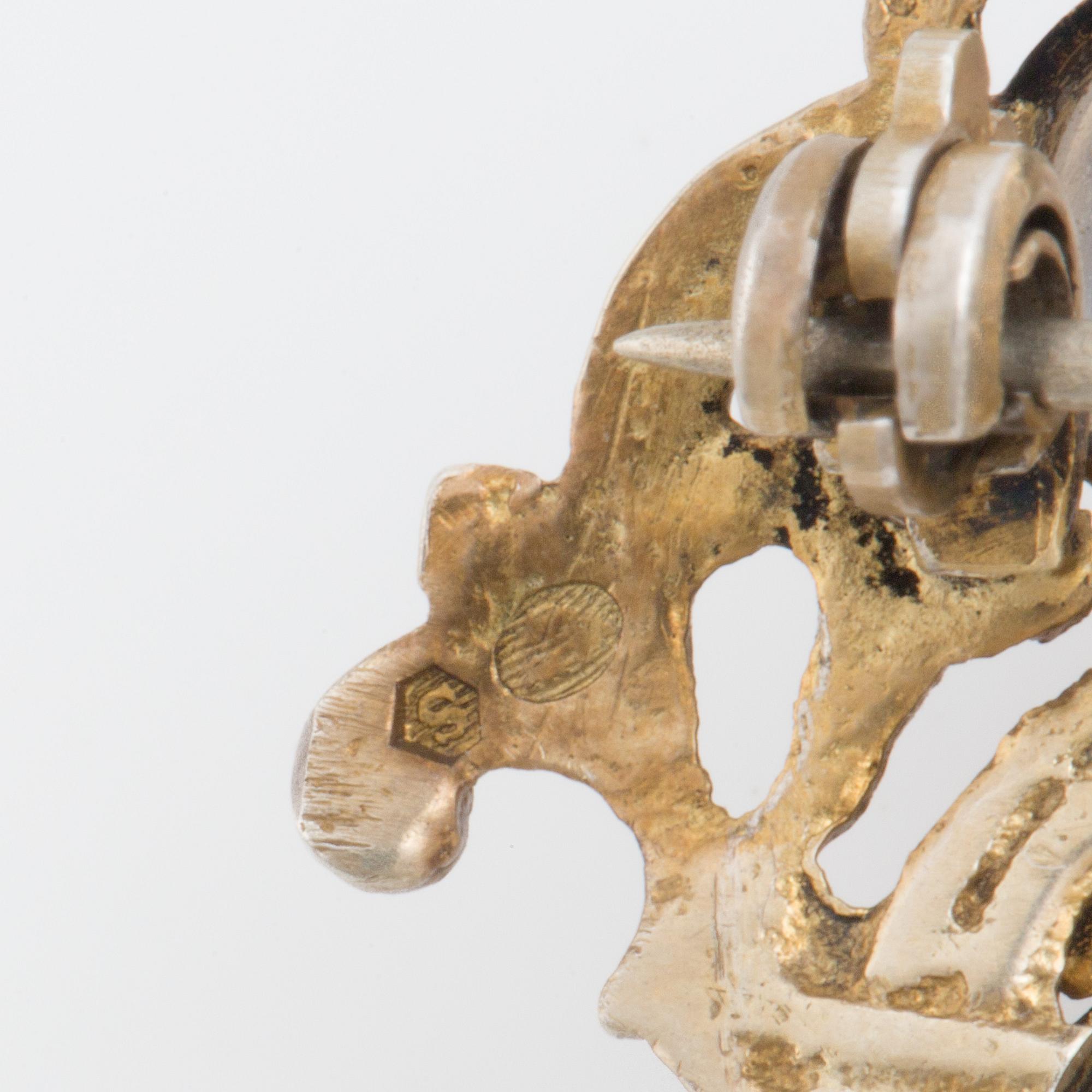 A brooch set with cabochon-cut moonstones.