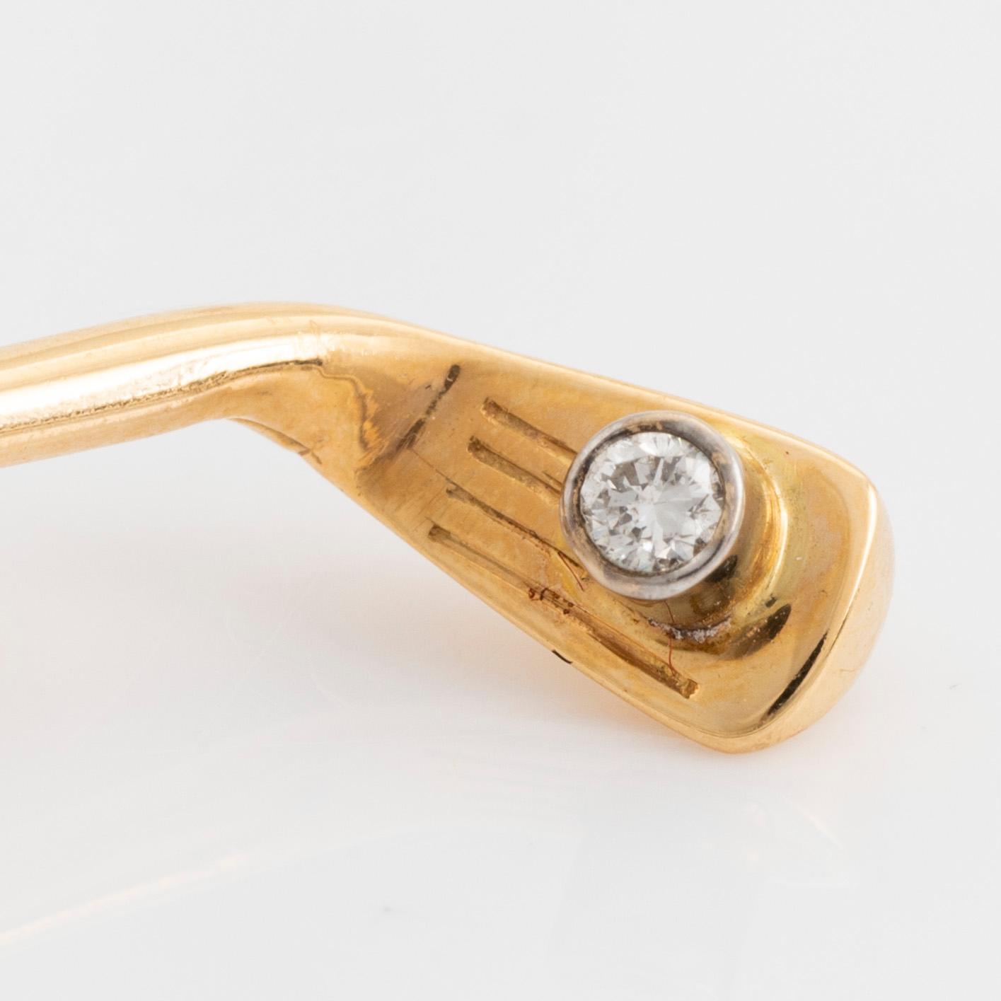 Slipsnål, 18K guld med briljantslipad diamant, i form av en golfklubba.
