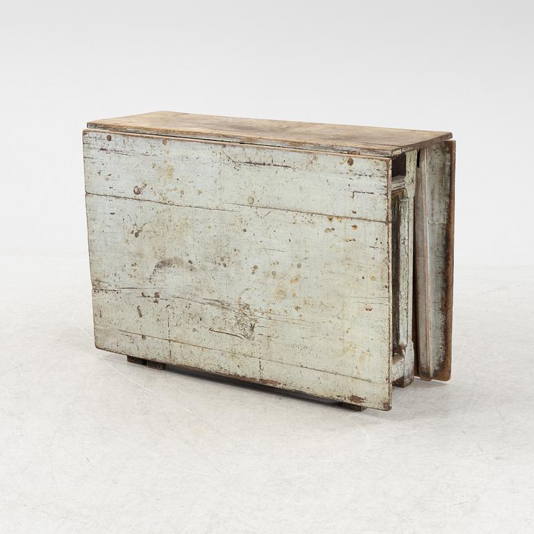 A 18th century gate-legged pine table.