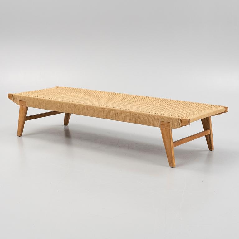 A contemporary teak daybed.