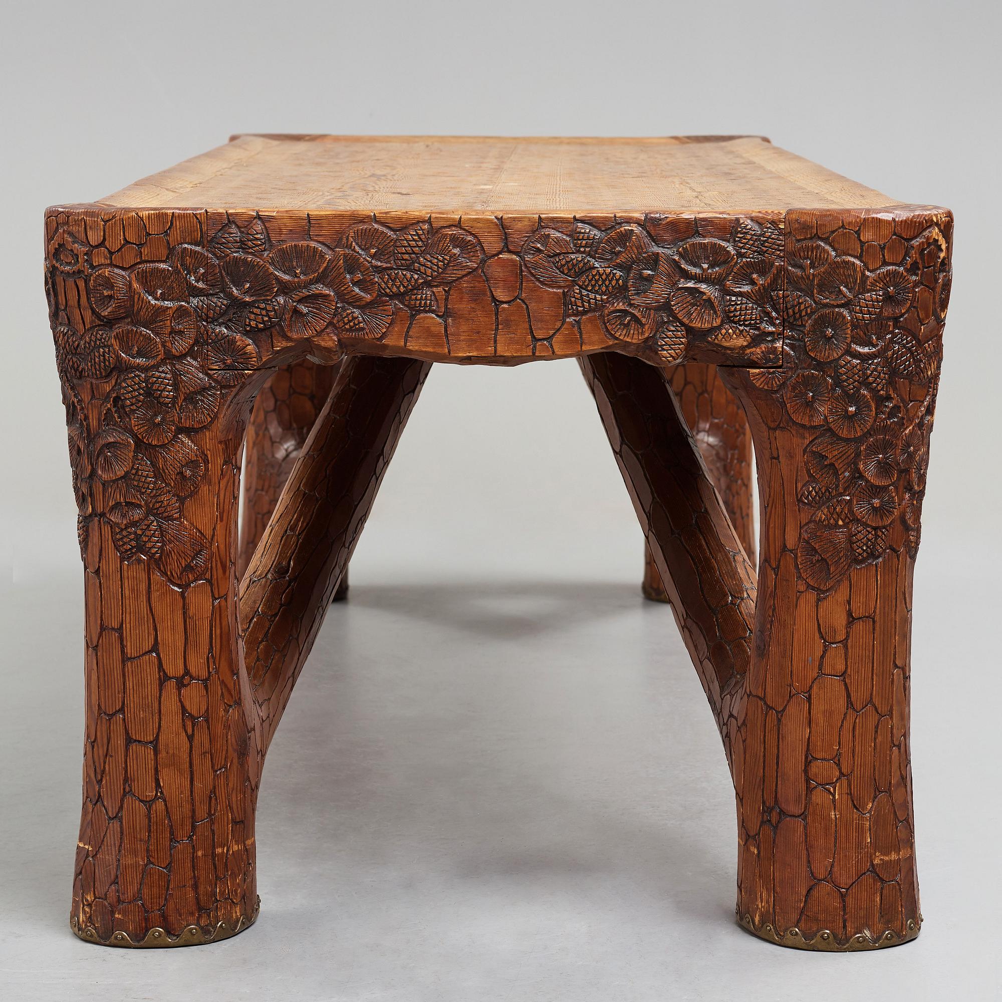 Gustaf Fjaestad, an Art Nouveau carved pine table, Arvika Sweden 1914, a double to the table in the Thiel Collection,