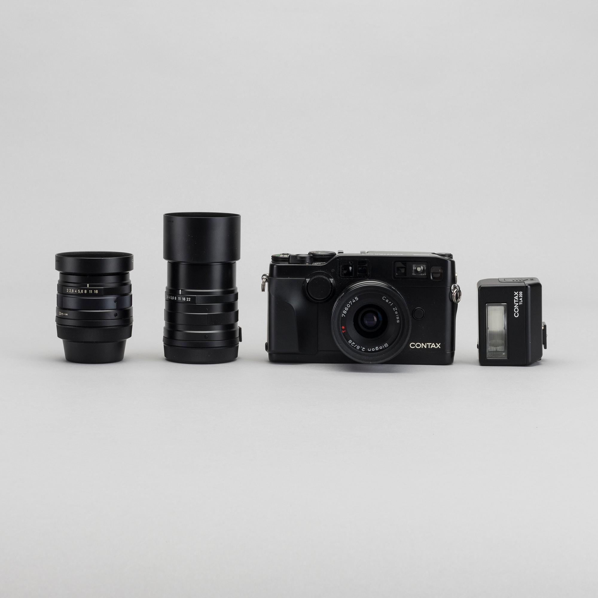 A black Contax G2 camera with 28mm, 45mm and 90mm lens and flash