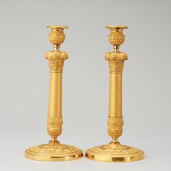 A pair of French Empire early 19th cenury gilt bronze candlesticks.