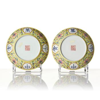 A pair of yellow-ground famille rose 'lotus' dishes, Qing dynasty, Jiaqing red seal mark and of the period (1796-1820).