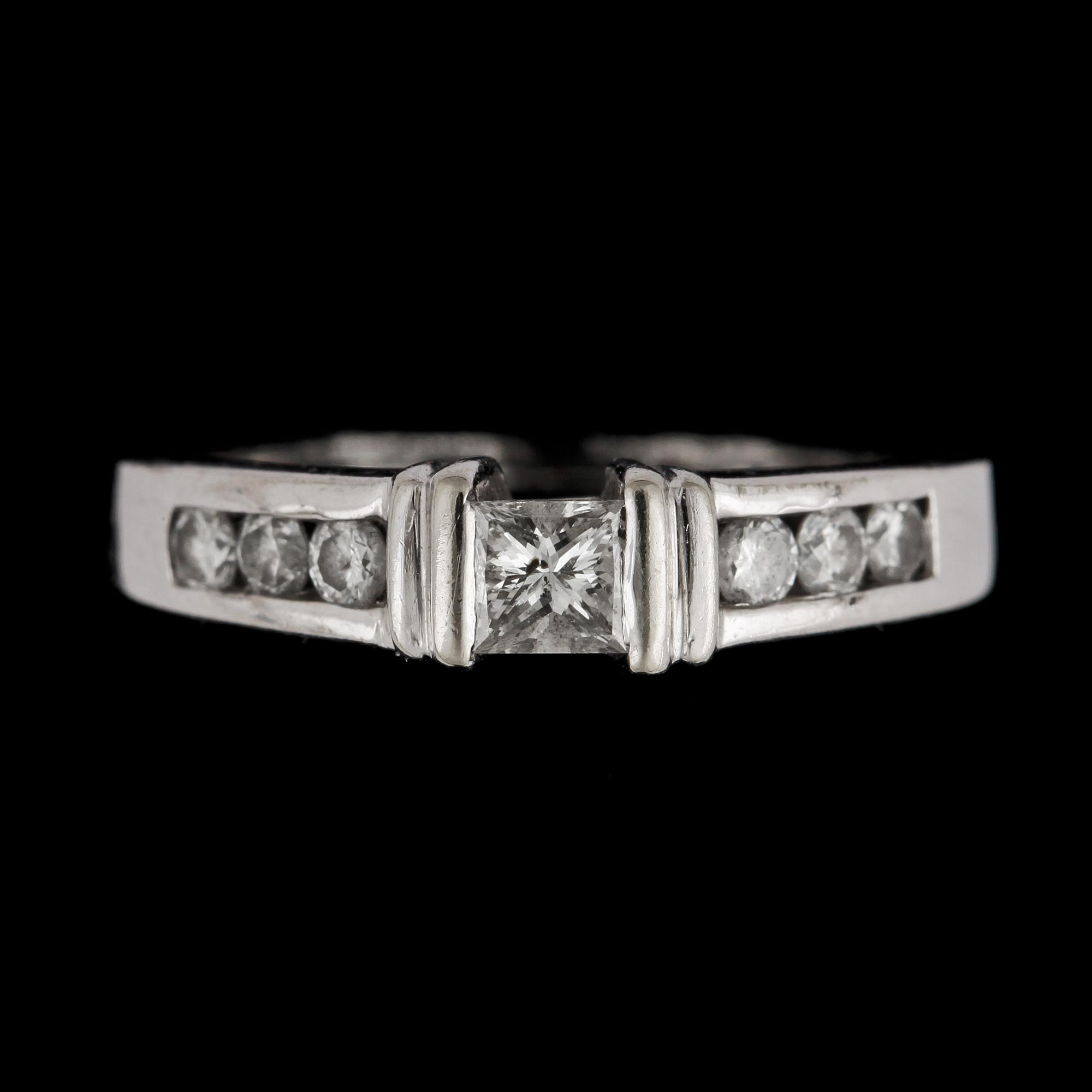 RING, 14k vitguld med prinsessslipad mittdiamant, ca 0,25ct samt 6st briljantslipade diamanter, tot ca 0,12ct. Vikt 3,4g.