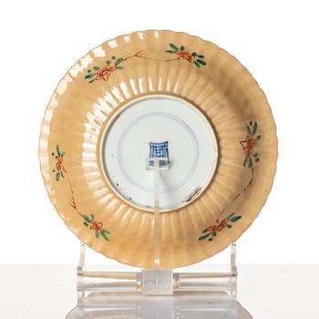 A Chinese iron red porcelain cup with saucer and a small famille verte dish, Qing dynasty, Kangxi (1662-1722).