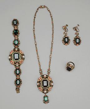 GARNITYR, 4 delar, silver och färgade glasstenar, emalj samt pärlor. Märkt PV. 1900-talets början.