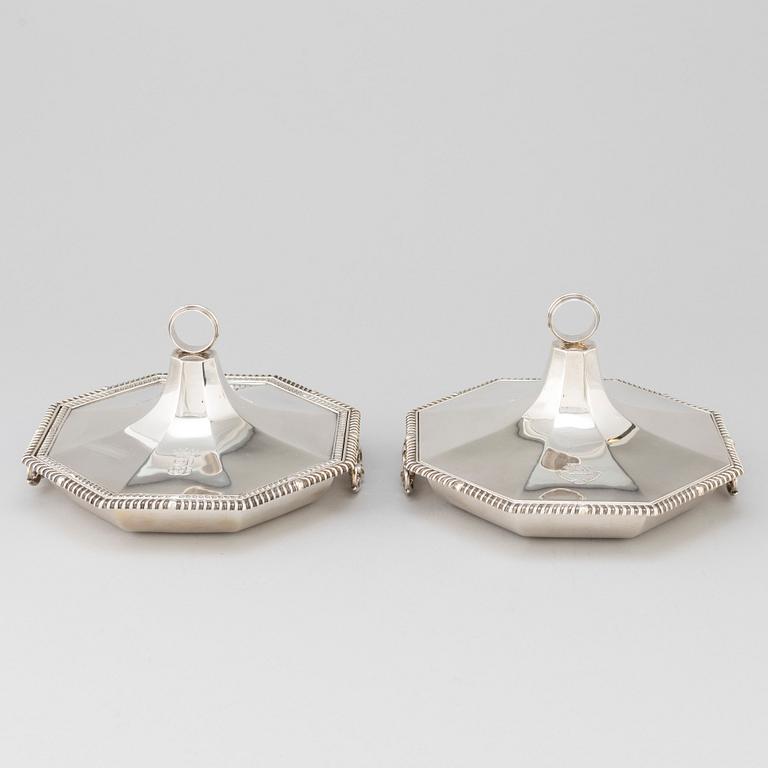 A matched pair of English silver dishes and covers, marked London 1910 and 1912.