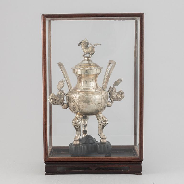 A Chinese metal incense burner in a wooden display case 20th century.