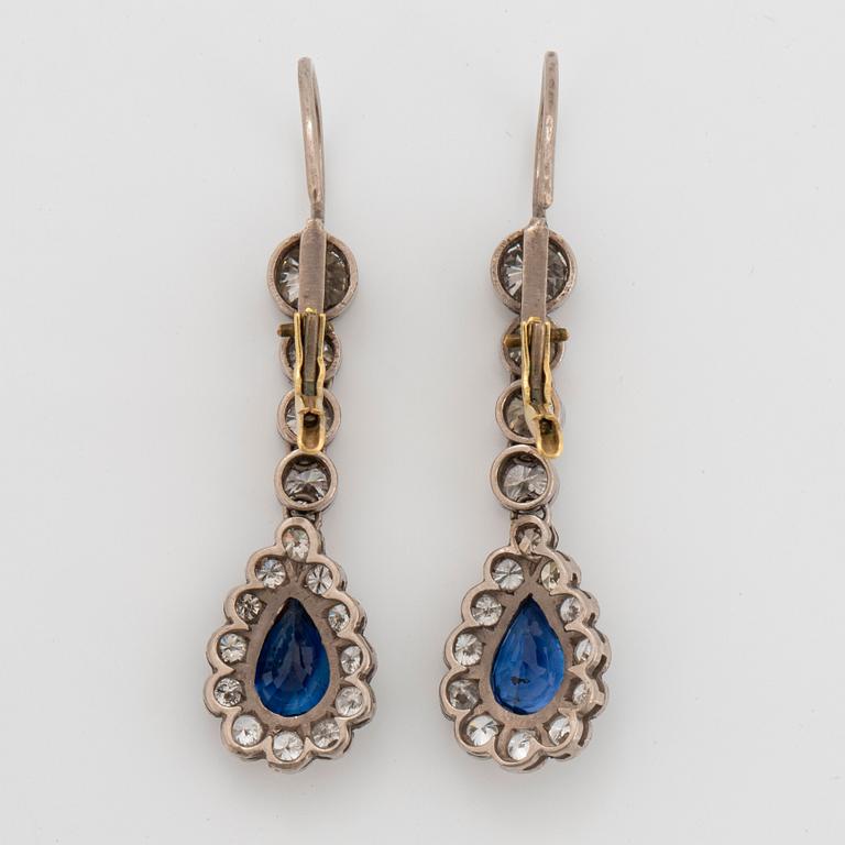 A pair of platinum and 14K gold earrings set with faceted sapphires and old-cut diamonds.