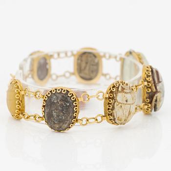Bracelet in 14K gold with various minerals and scarab-shaped charms.