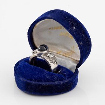 Ring in 18K white gold set with a cabochon-cut sapphire and brilliant-cut diamonds, Kenneth Magnell.