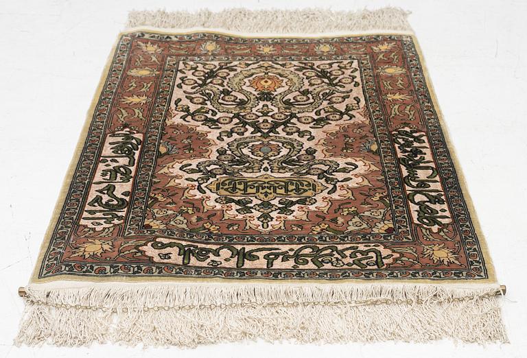 A silk Hereke rug, c. 77 x 53 cm.