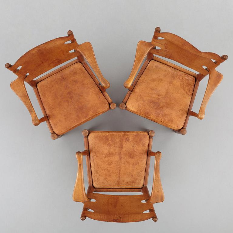 SCANDINAVIAN MODERN, a set of three mid 20th century mahogany and brown leather easy chairs.