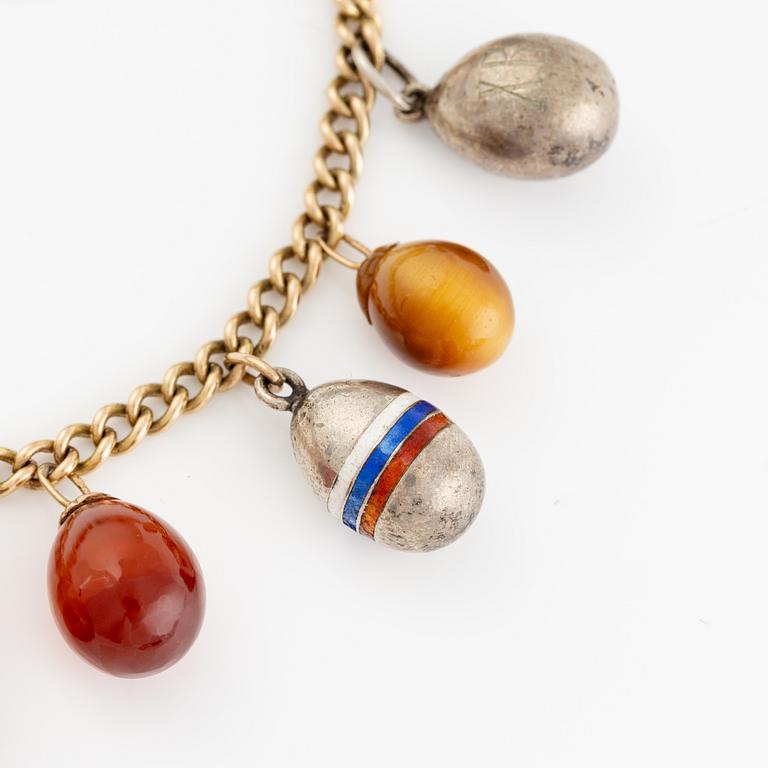 Bracelet with charms in the shape of eggs, the bracelet is 14K gold and 13 loose charms in the shape of eggs.