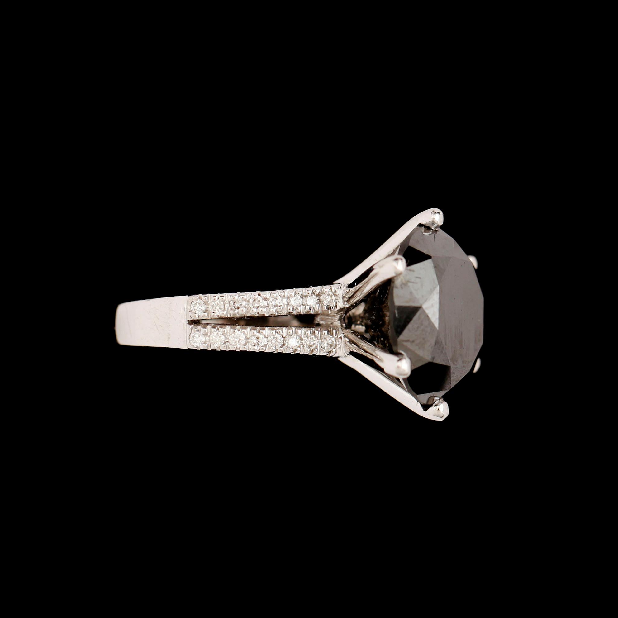 RING, 18 k vitguld, svart briljantslipad diamant 11.74 ct, samt 36 mindre briljanter tot ca 0.32ct.