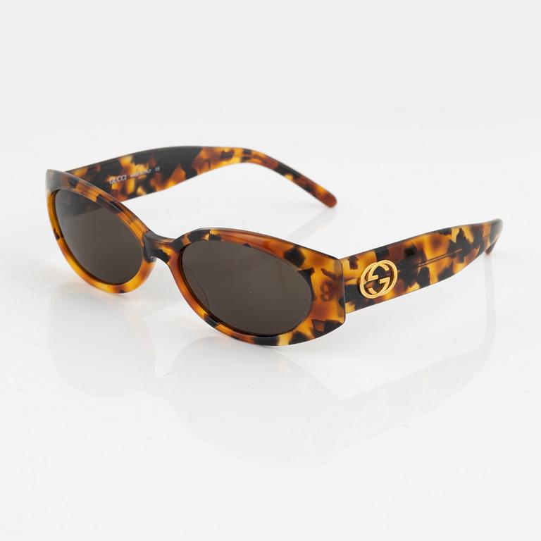 Gucci, a pair of gold tone logo sunglasses.