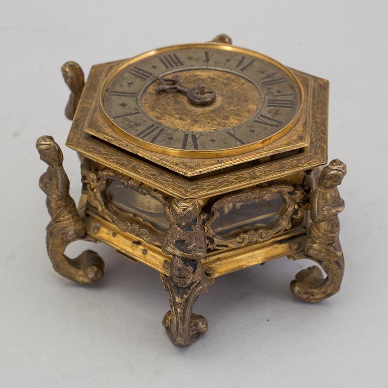 A gilded brass baroque travel clock from around 1700, with original case.
