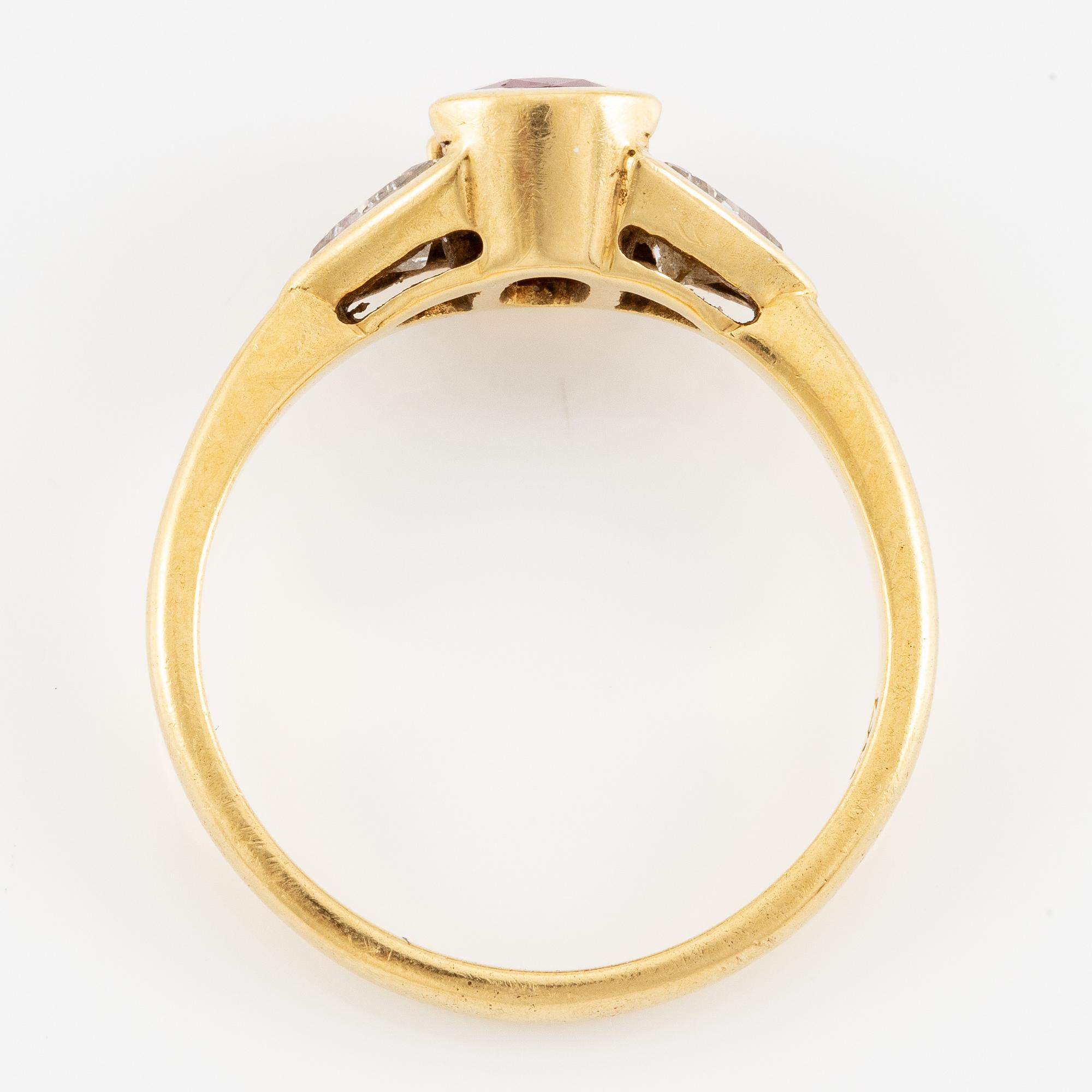 Ring 18K guld med en fasettslipad rubin samt två triangelformade briljantslipade diamanter.