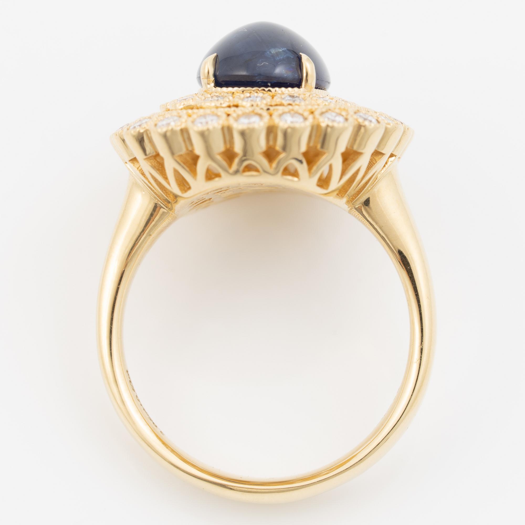 Ring in 18K gold set with a cabochon-cut sapphire and brilliant-cut diamonds.