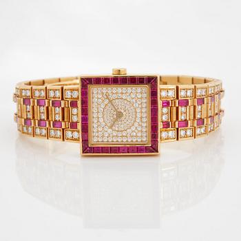 A Bulgari wristwatch in 18K gold set with step-cut rubies and round brilliant-cut diamonds.