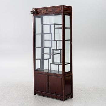 A Chinese display cabinet, wood and glass, later part of the 20th century.