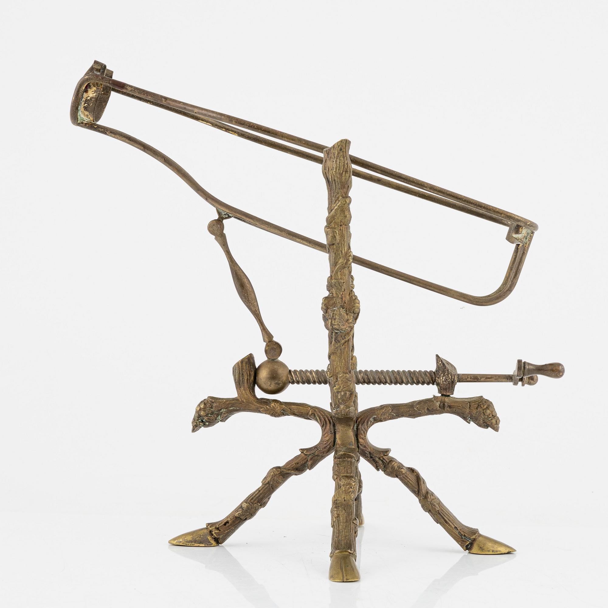 A brass bottle holder, circa 1900.