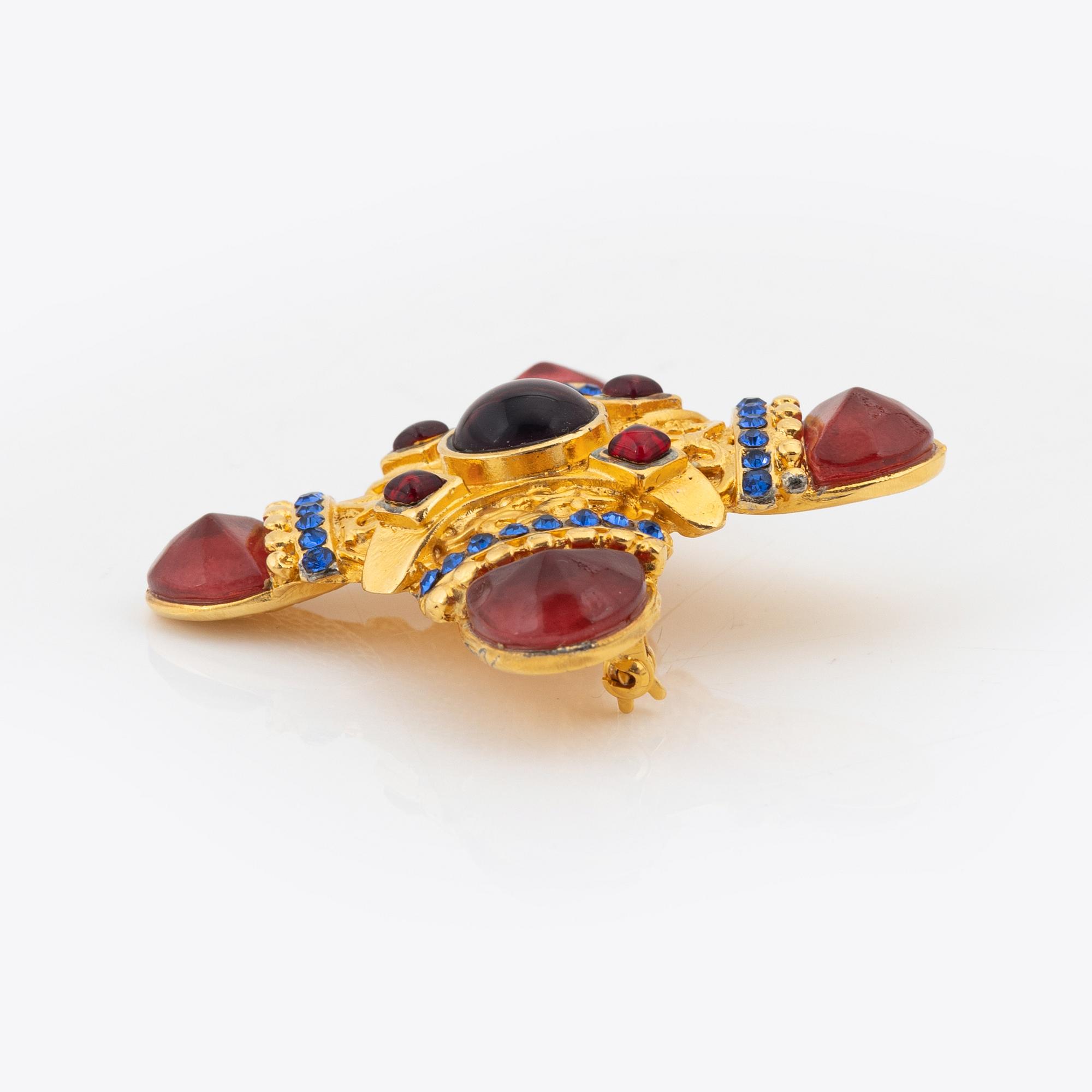 Gianni Versace, a gold tone and glass stone brooch.